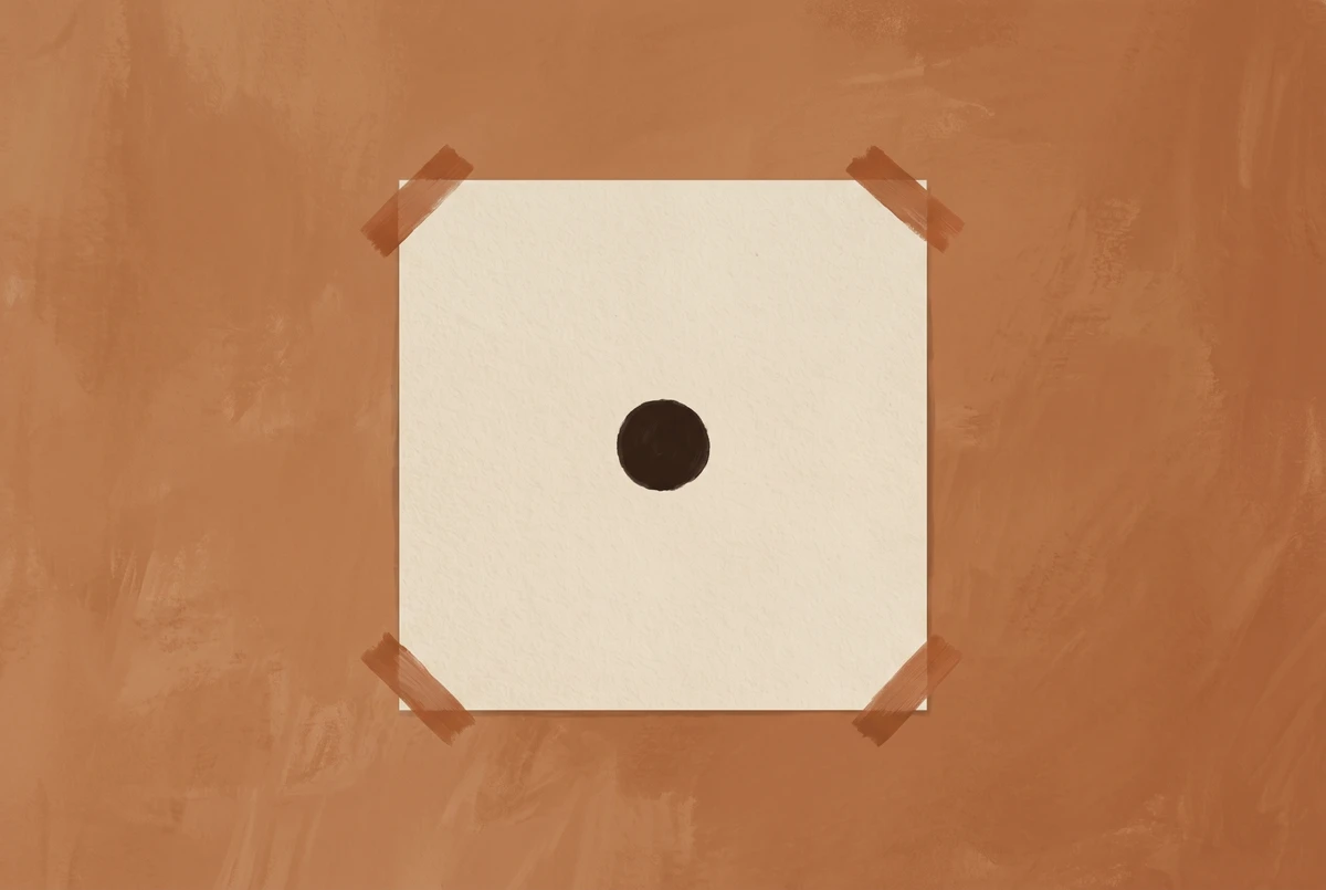 A small black dot on a cream paper square taped to an earthy wall as a trataka concentration object