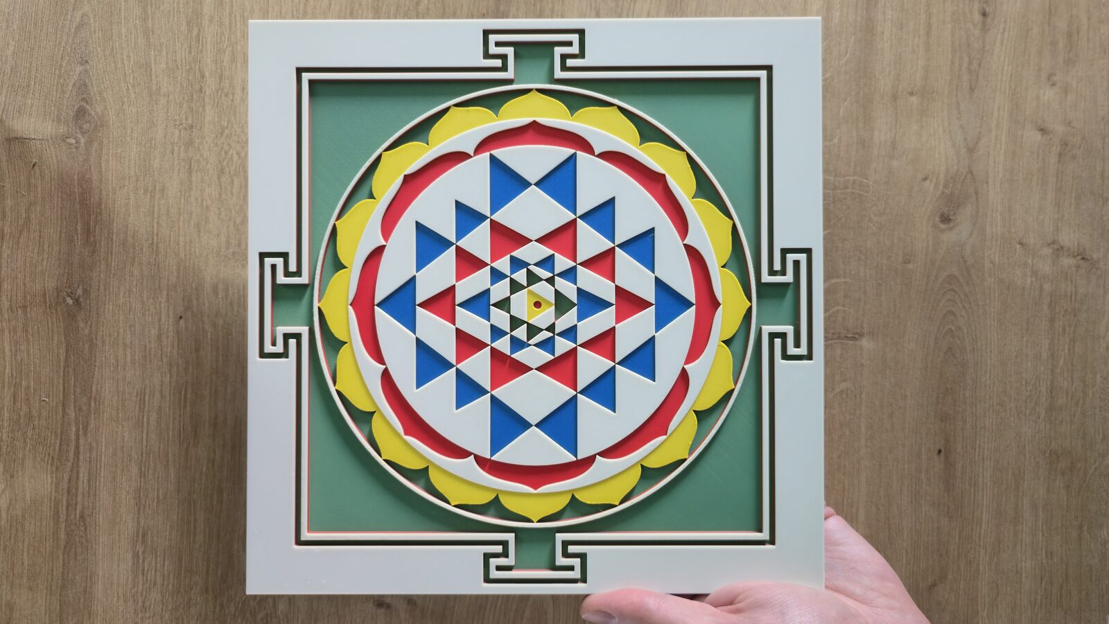 Two hands holding the Sri Yantra from above