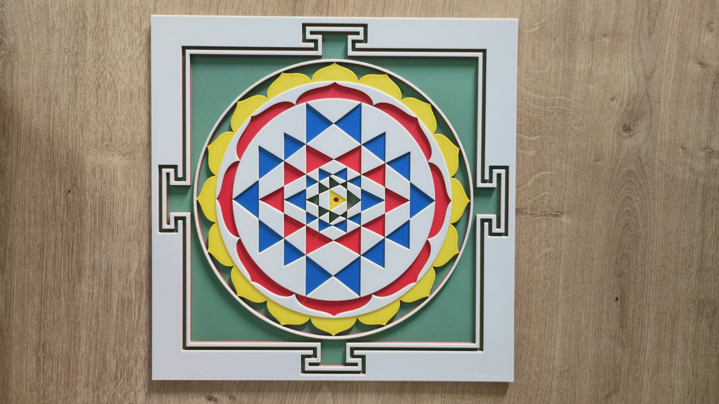 Sri Yantra meditation panel with nine interlocking triangles in green, red, blue, yellow, and white